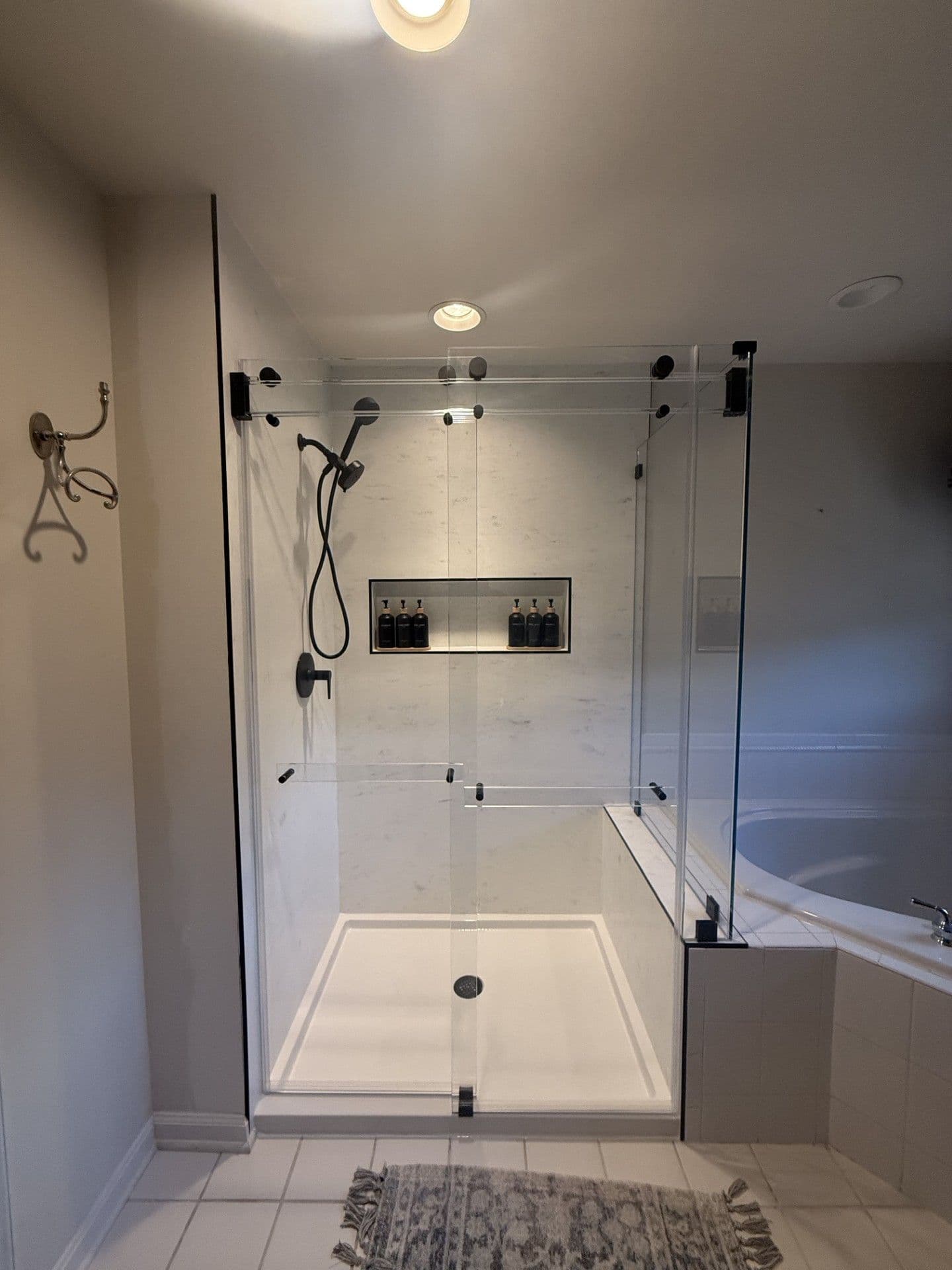 Custom Composite Shower Walls in Calacatta Marble with custom contemporary double-sliding enclosure with a buttress return